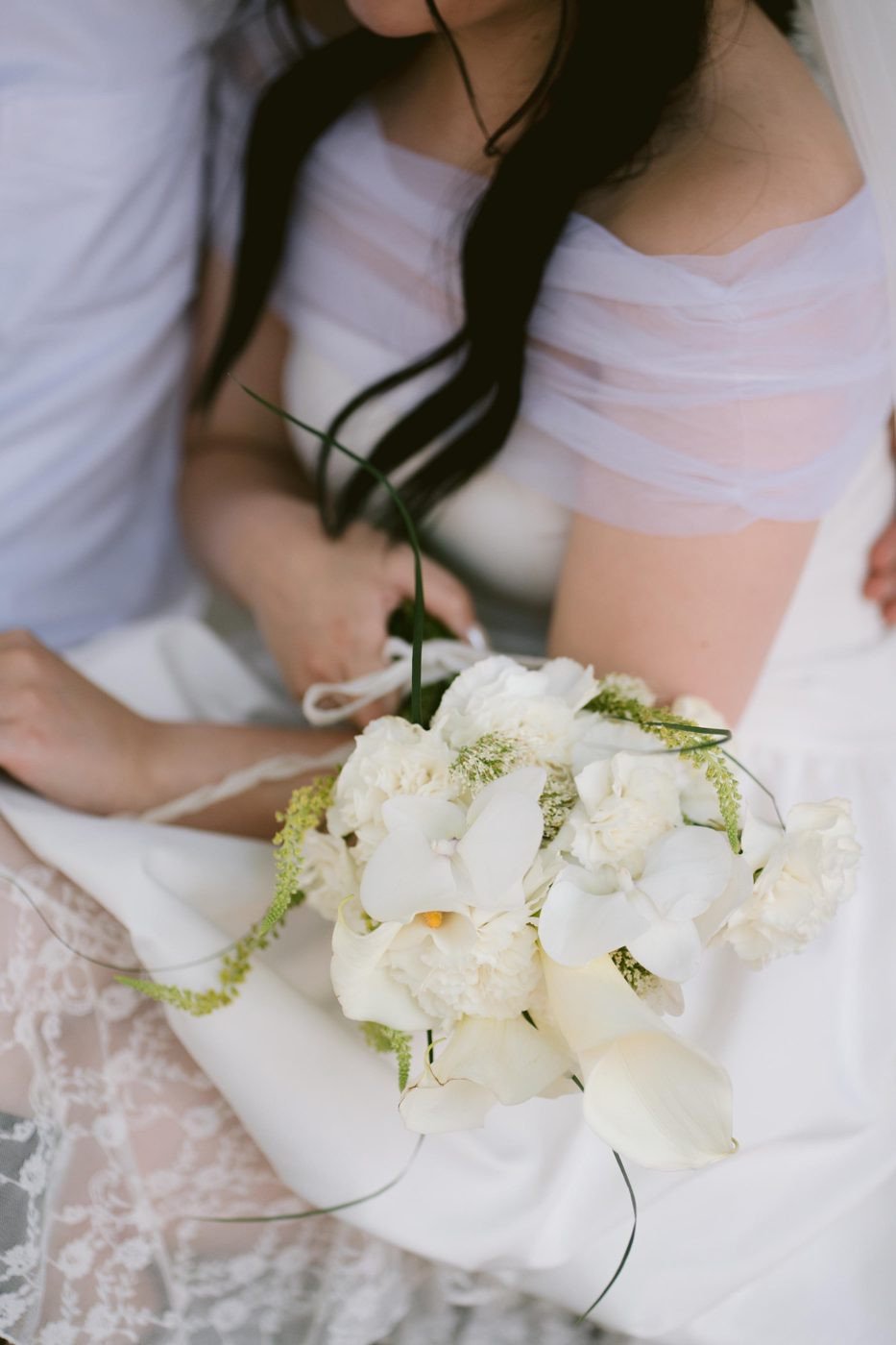 Ramo de novia blanco sobre el vestido